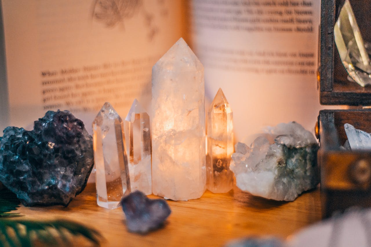 services-06 Close-up of various healing crystals on a wooden table with warm lighting