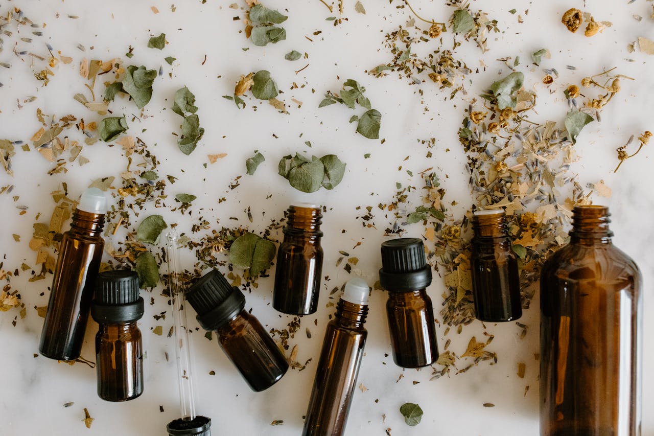 about-us Flat lay of brown glass bottles and dried herbs, perfect for aromatherapy themes.
